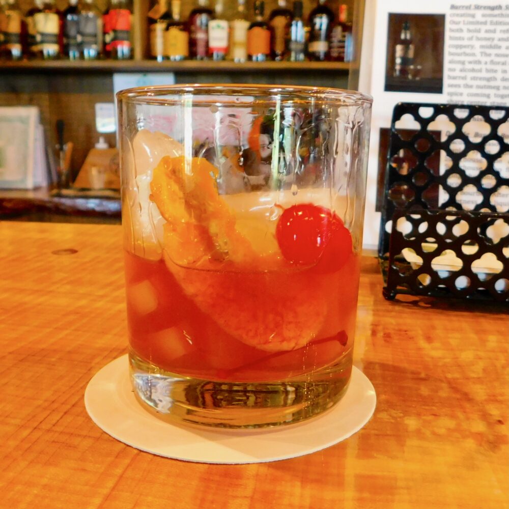 The taconic distiller's smoked manhattan is a classic, served in a high-ball glass with a cherry and twist of orange.