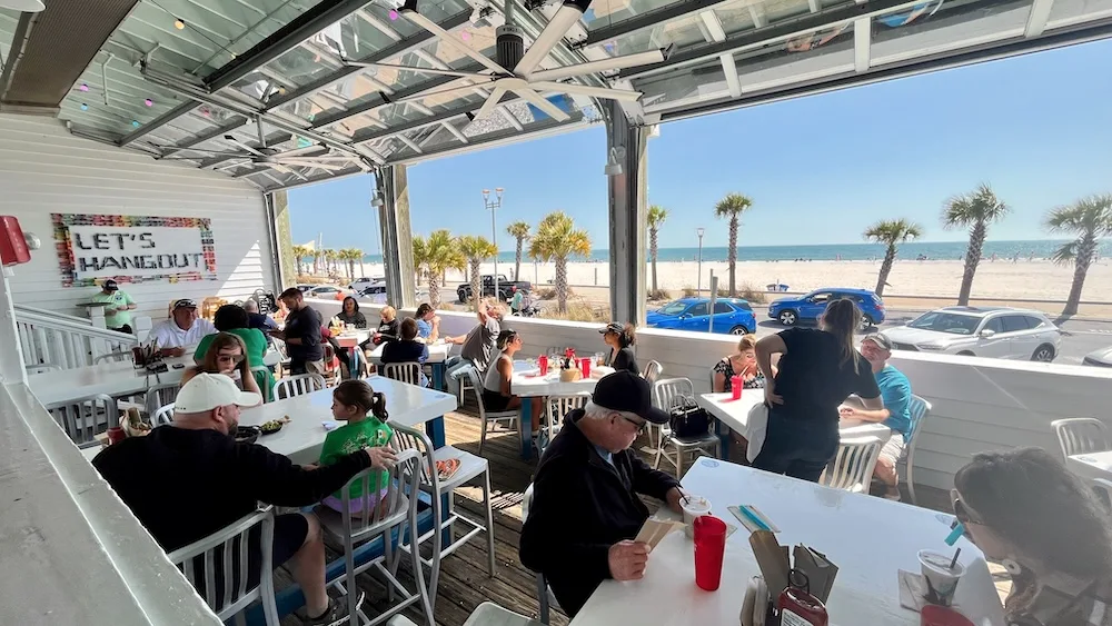 The front deck at the hangout at gulf shores has a beach view and beach vibe as well as good food.