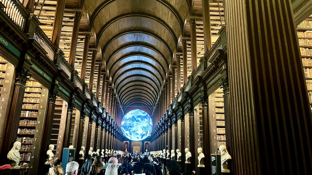 The long room at trinity college in dublin is aptly named and impressive to walk through with its tall arched wooden ceiling, busts of famous thinkers and two levels of books on open shelves.