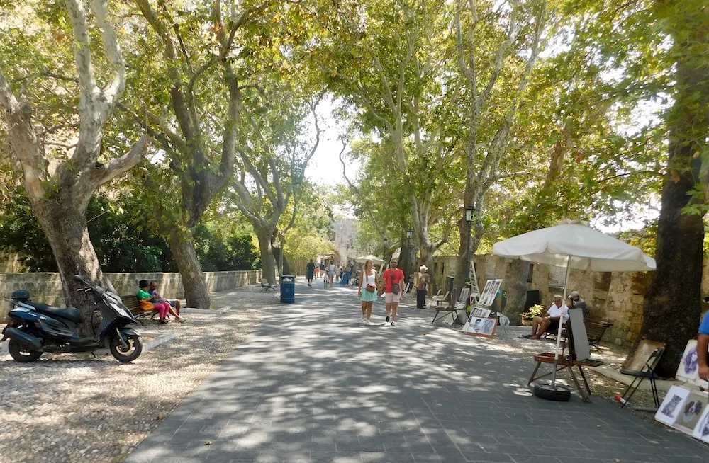 part of the medieval walls around the rhodes old town is a broad, tree-line promenade.