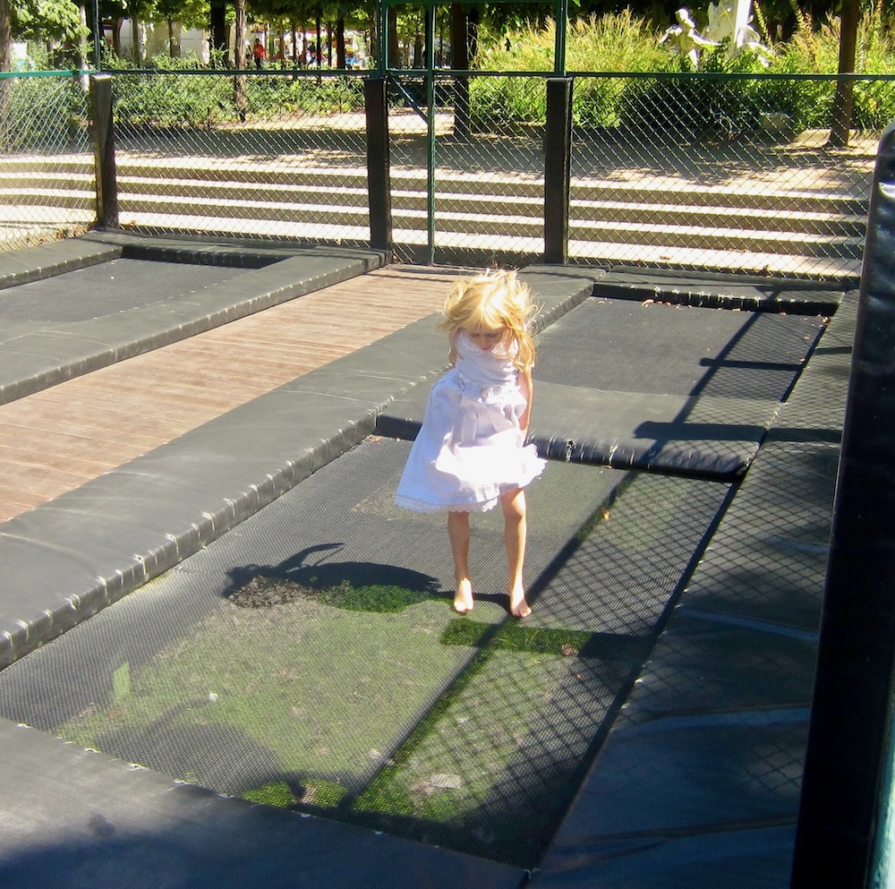 one of the best, cheap things to do in paris with kids is to take them to the trampolines in the tuileries gardens.