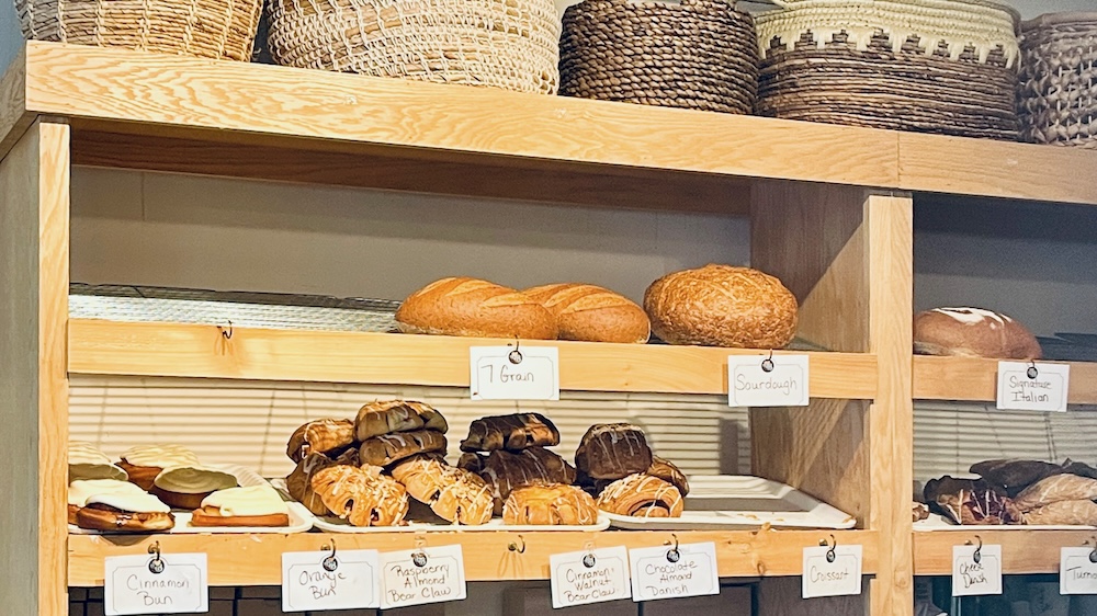 the shelves at bread basket bakery in saratoga are filled in the morning with pastries, croissants and fresh loaves of bread.