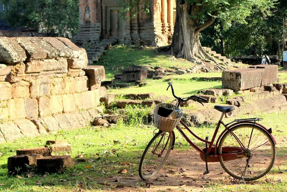 A bicycle with a handy basket is parked while its rider explores the ruins of buddhist temples around siem reap, cambodia